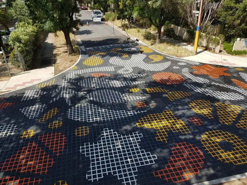 White and orange floral pattern decorating a tree lined street