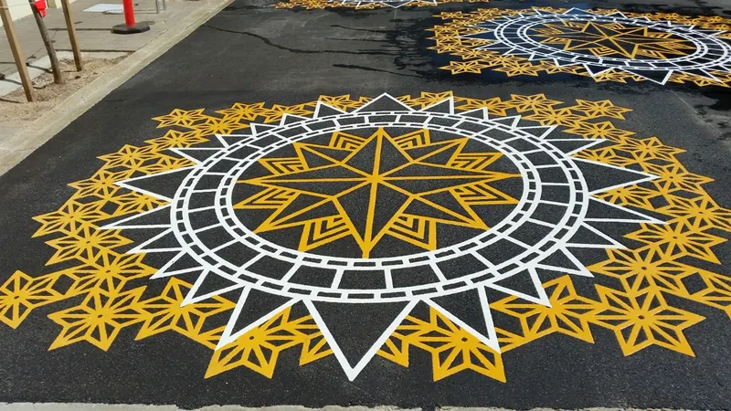 Gold and white star compass mandala applied to asphalt