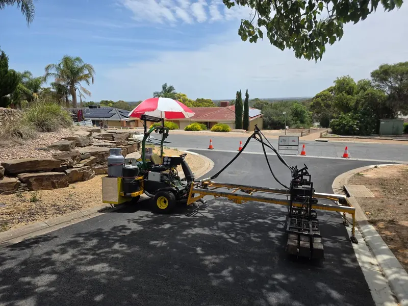 Infrared asphalt repair in progress on a residential street corner