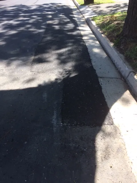 Seamless asphalt patch repair blended into the road with no visible joins