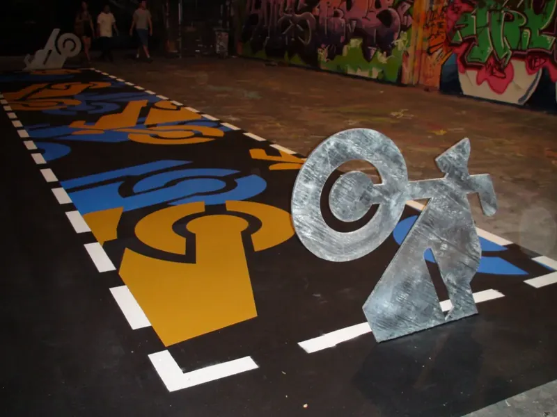 Street art laneway floor with sculpture and graffiti wall backdrop