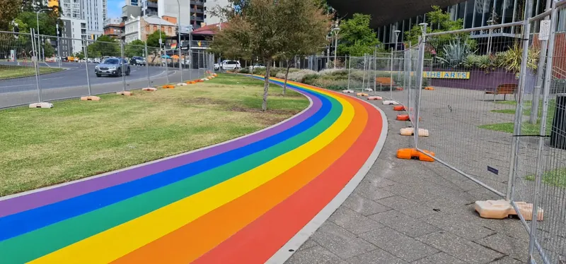 Rainbow coloured StreetBond path curving around parkland lawn