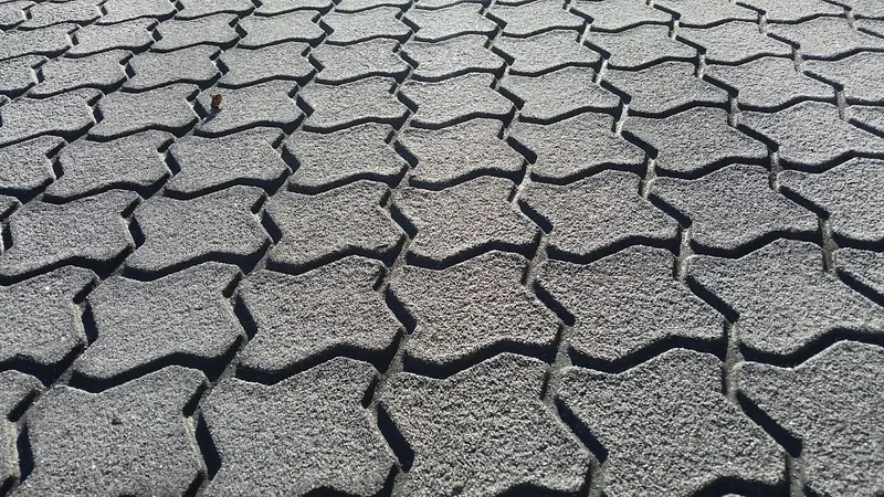 Interlocking paver texture stamped into grey asphalt