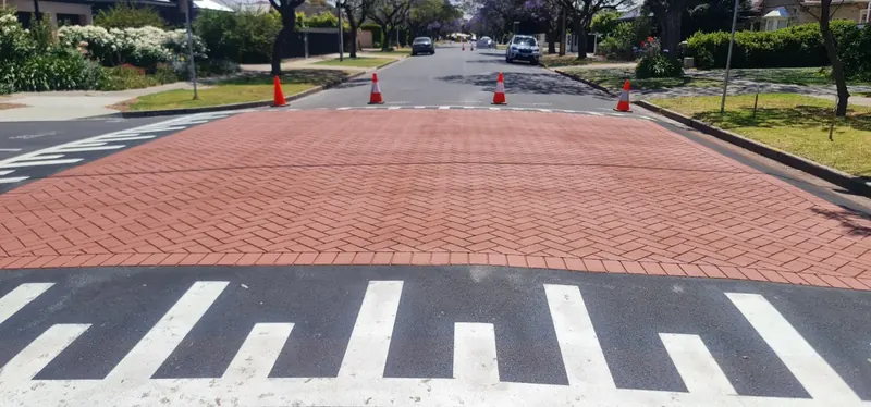 Red brick stamped asphalt pedestrian crossing with white bars