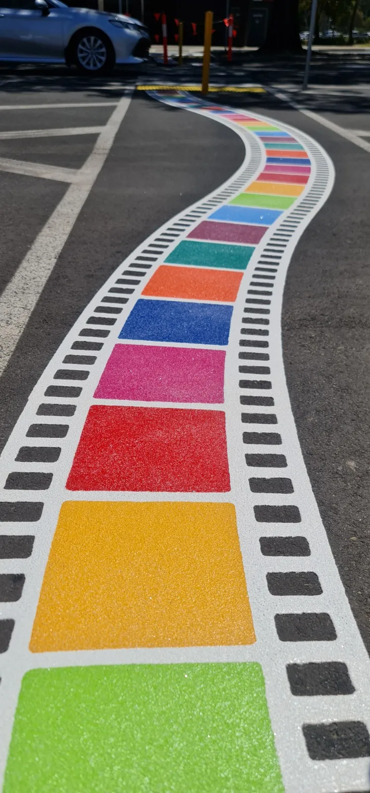 Rainbow filmstrip pattern running along a path edge
