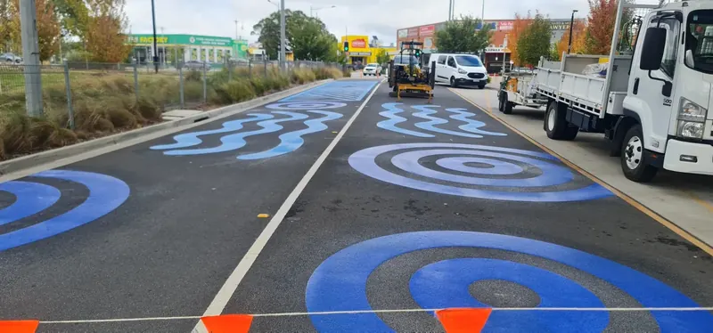 Blue water ripple and raindrop pattern along a main road
